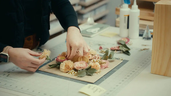 Artisan arranging flowers for a shadow box wedding bouquet preservation