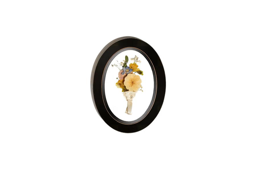 Oval Rubbed Black wooden frame displaying pressed groom Boutonniere.