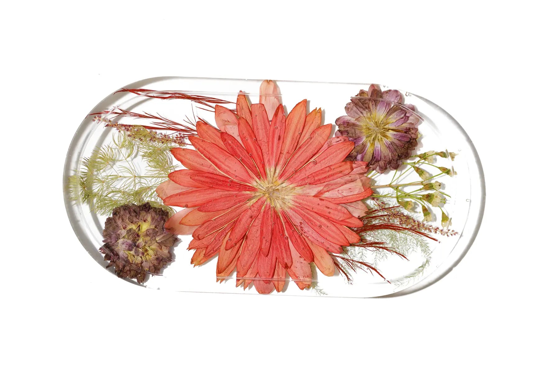 An oval resin preservation dish made with preserved wedding flowers in red and purple colors.