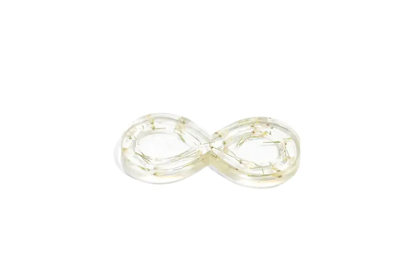 Infinity shaped ring dish made with clear resin featuring white wedding flowers.