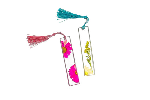 Two floral resin bookmarks with tassels in purple and pink.