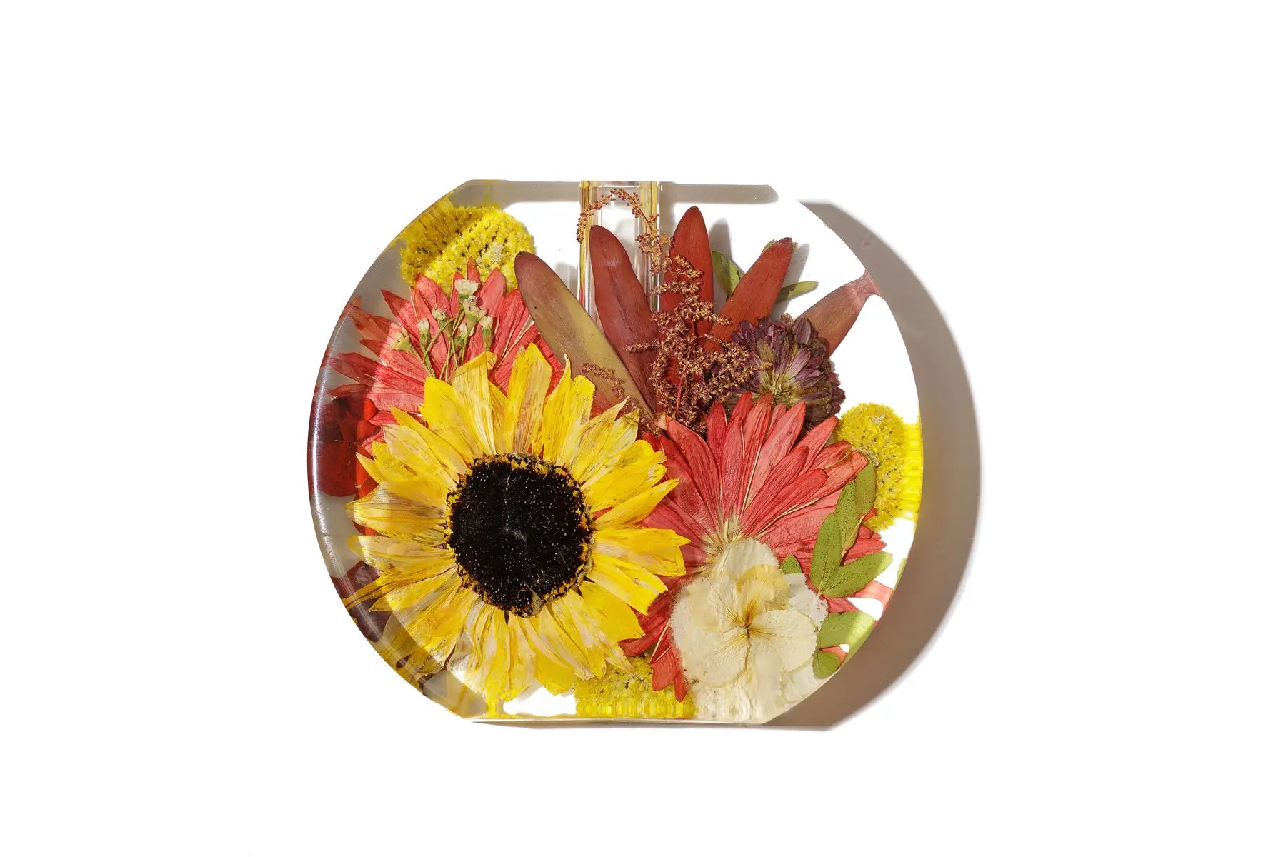A rounded with flat bottom flower vase made of resin preserved flowers.