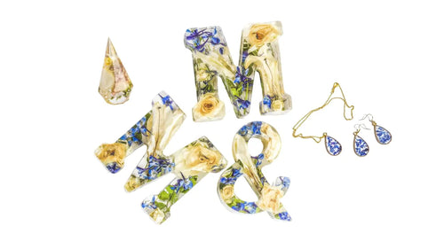 Decorative letters 'M', '&', 'M' with preserved flowers, matching resin flower earrings, and a resin ring holder.