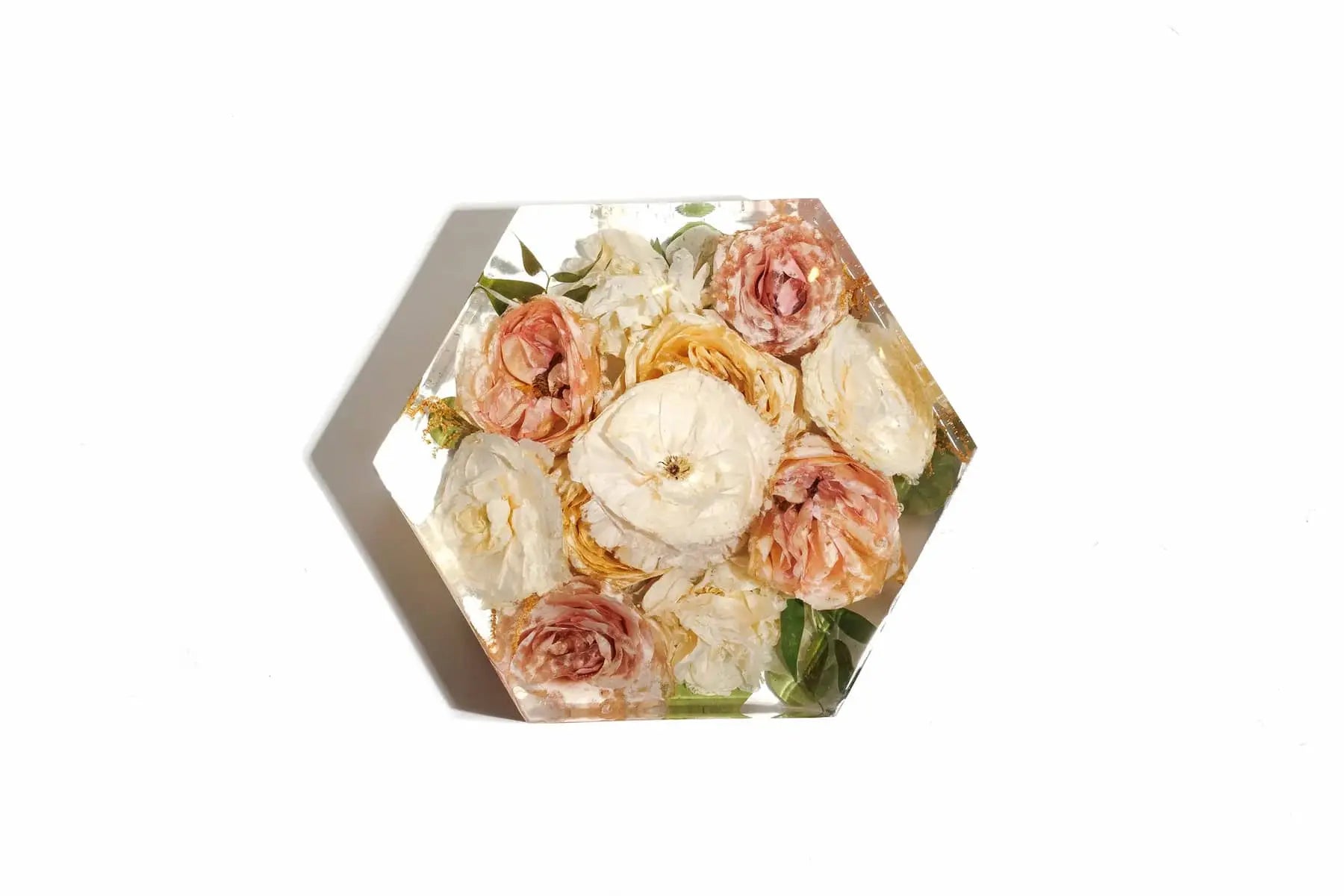 Pink carnations preserved in a clear resin bouquet block in a hexagon shape