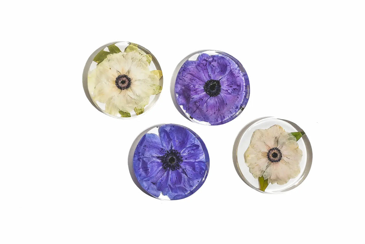 Four round circle resin coasters with pressed flowers.