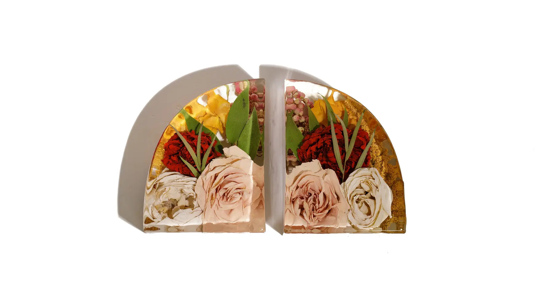An autumnal wedding bouquet with pink roses preserved in a pair of resin bookends