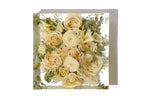 A small square 6 inch of ranunculus and roses preserved in clear resin.