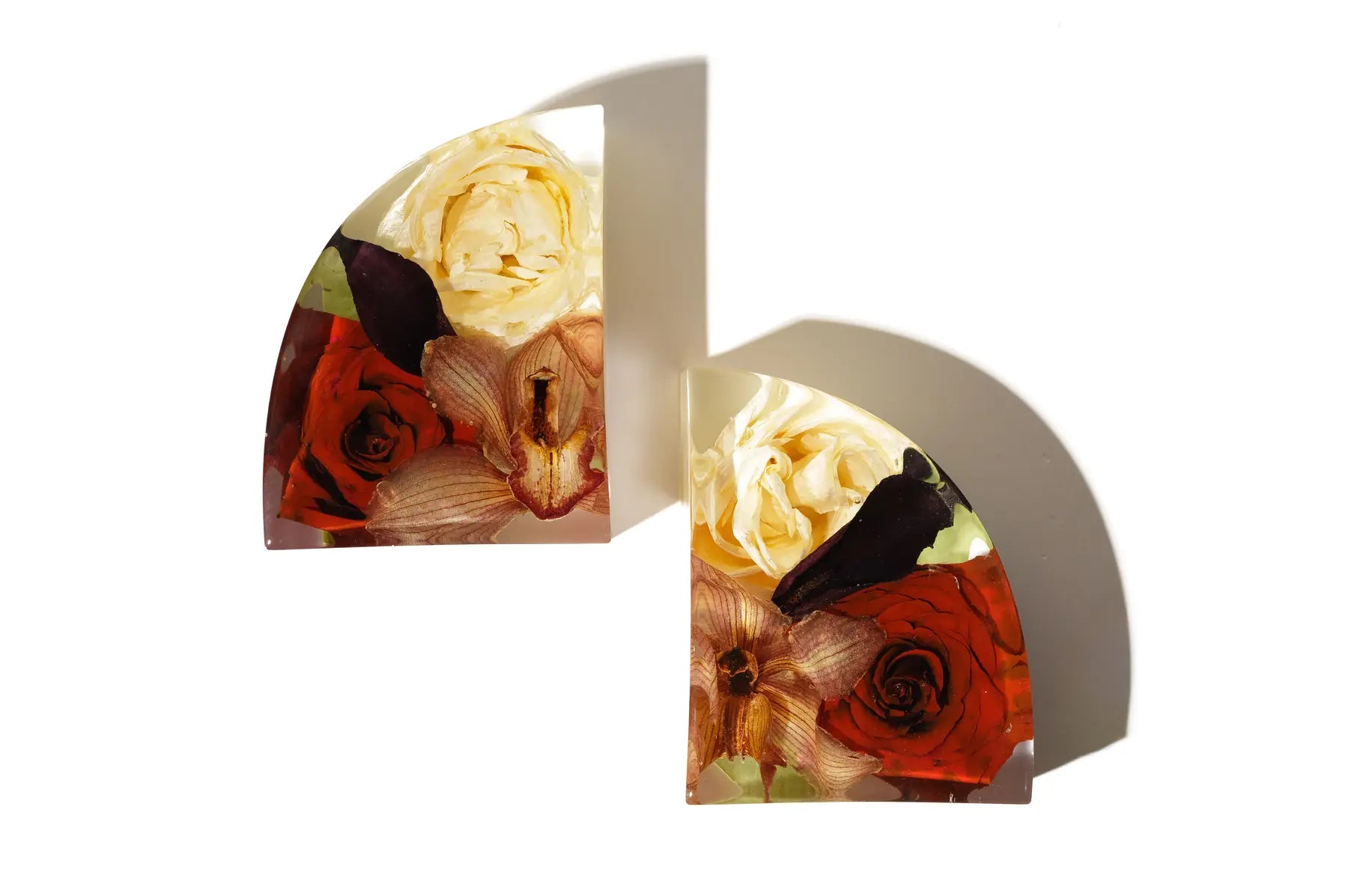 Red roses and carnations preserved in large resin bookends