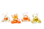 Four small resin bear figurines with wedding bouquet preservations inside of them