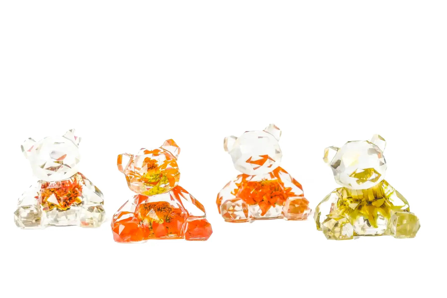 Four small resin bear figurines with wedding bouquet preservations inside of them