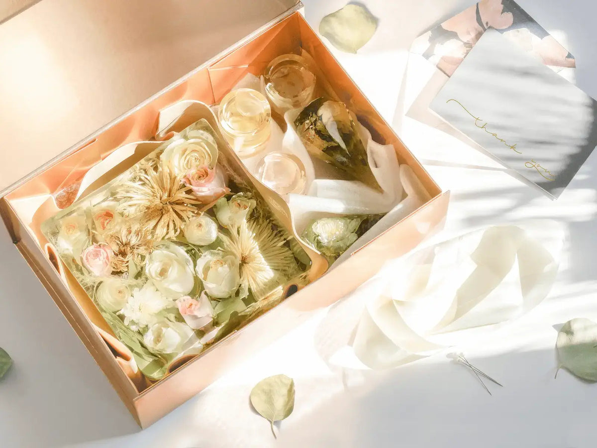 Gift boxed preserved wedding flowers in a square bouquet block and candle votives and ring holders in a clear resin