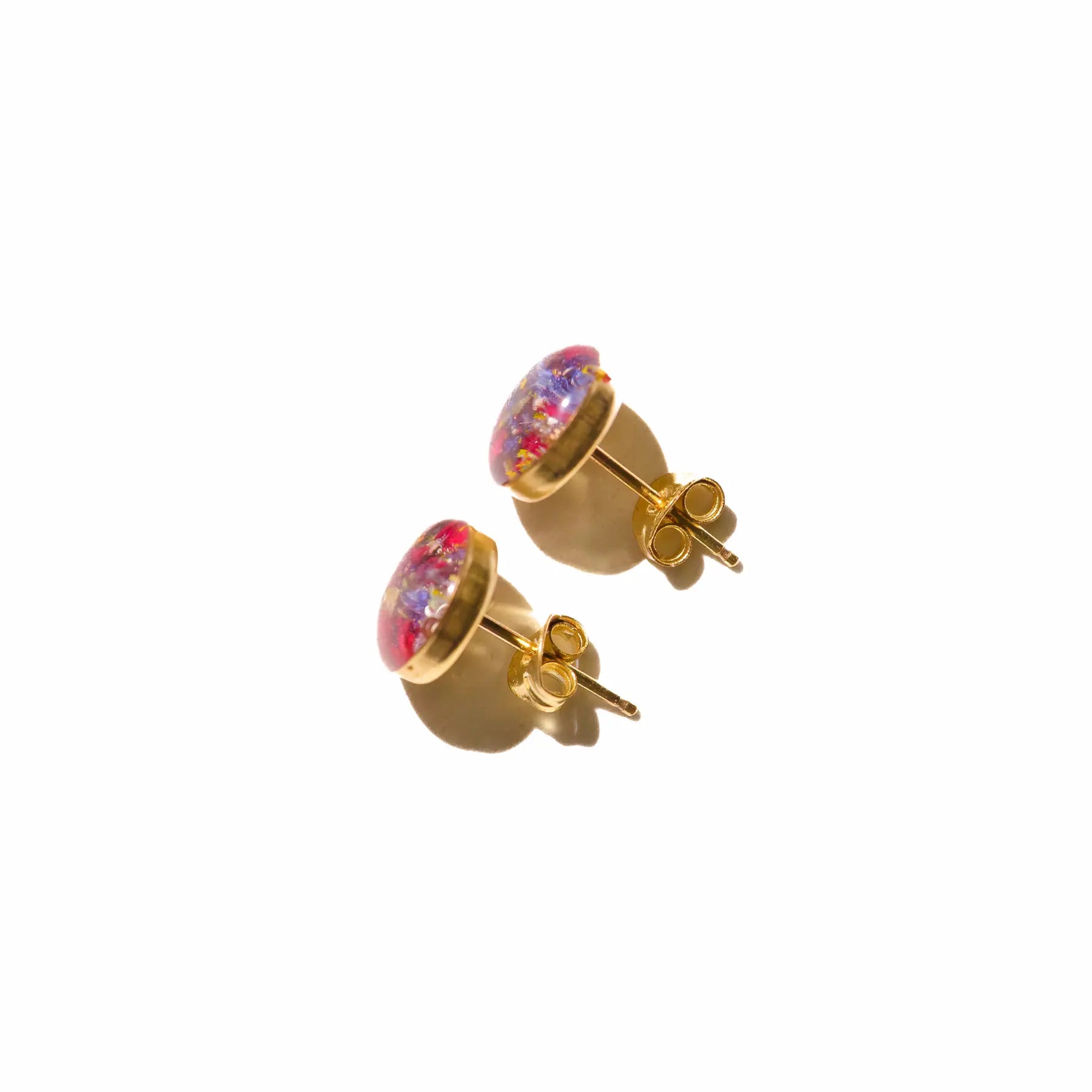 Gold stud earrings with colorful resin flowers preserved from a wedding