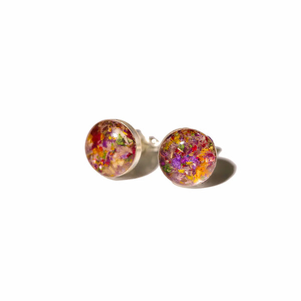 Colorful round earrings with gold studs made with resin preserved flowers.