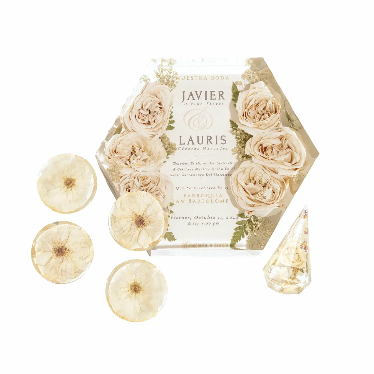 Hexagon bouquet block made of clear resin preserving white roses that surround a wedding invitation, four resin flower coasters, and a rose filled ring holder.