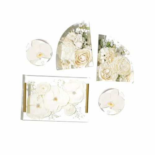 Two large resin flower bookends, two resin preservation coasters with white flower, and a matching resin serving tray with gold handles.