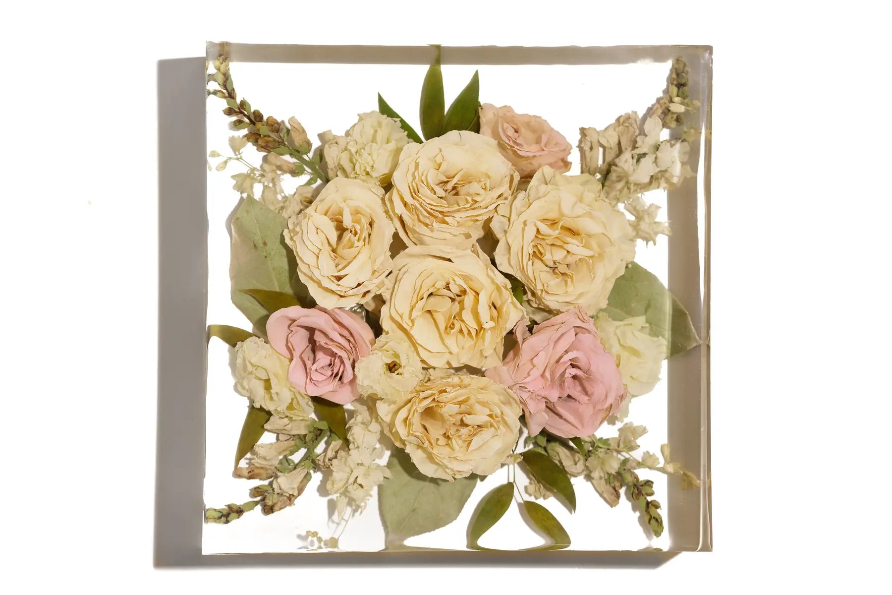 A wedding bouquet of roses forever preserved in a large resin square bouquet block.