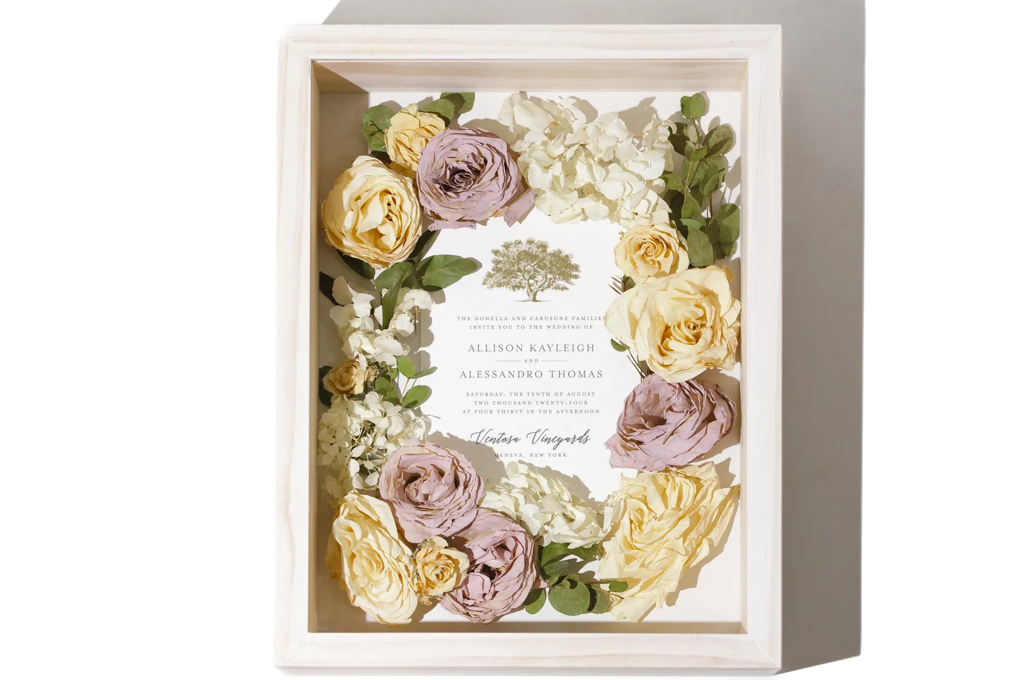 Preserved flower arrangement in a decorative shadow box featuring a wedding invite