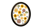 Autumnal flowers in a unique design featured in a black oval wood frame