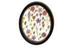 An oval handmade wooden black frame with a spaced design of pressed and preserved flowers with clear background