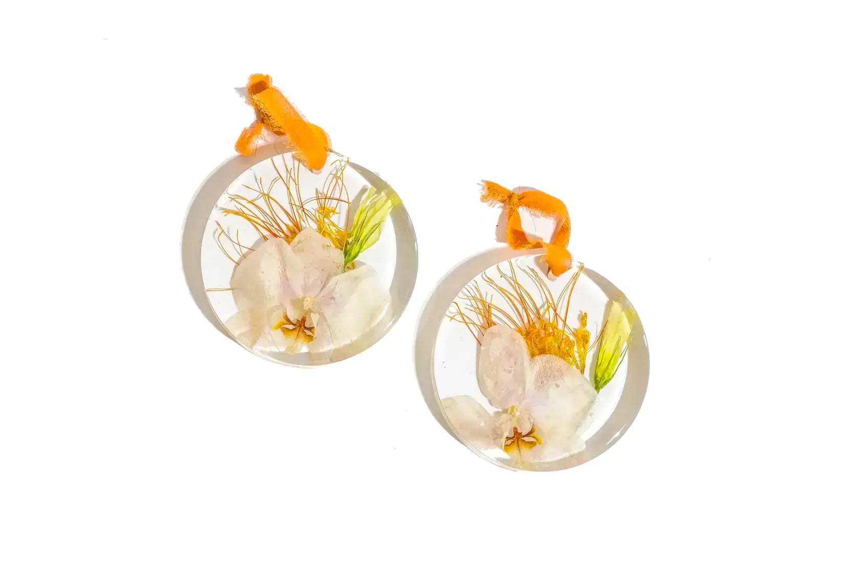 Pair of resin preservation ornaments with white flowers and natural fabric hang tags