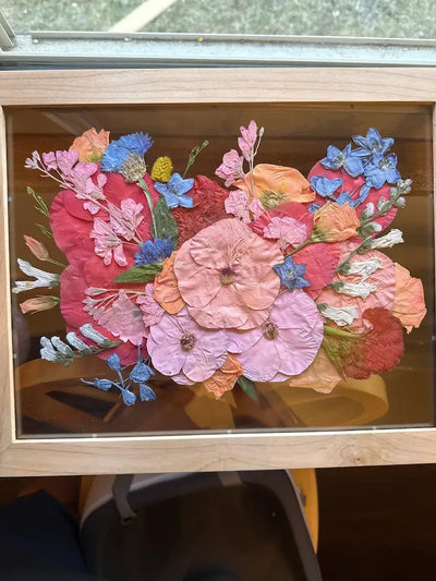 Colorful roses wedding arrangement in a light brown wood frame