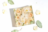 Square resin block with white anemone surrounded by white roses in a white background
