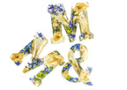 Decorative letters 'M', '&', 'M' made of wedding flowers preserved forever in resin