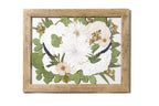 Framed, pressed and preserved floral arrangement with white flowers and green leaves in a floating design.