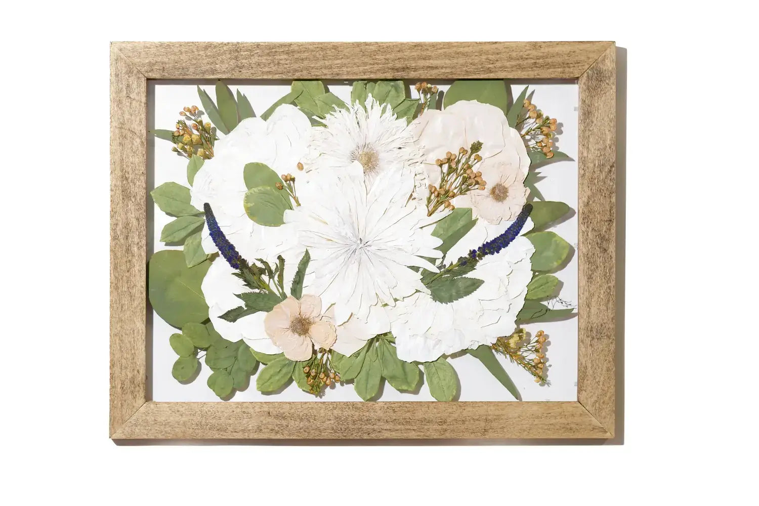 Framed, pressed and preserved floral arrangement with white flowers and green leaves in a floating design.