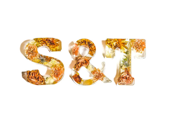 Decorative resin letters 'S', an ampersand '&', 'T' made of pressed wedding bouquet of falltime flowers