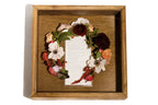 Wooden shadow box frame with floral wreath and vows card center framed
