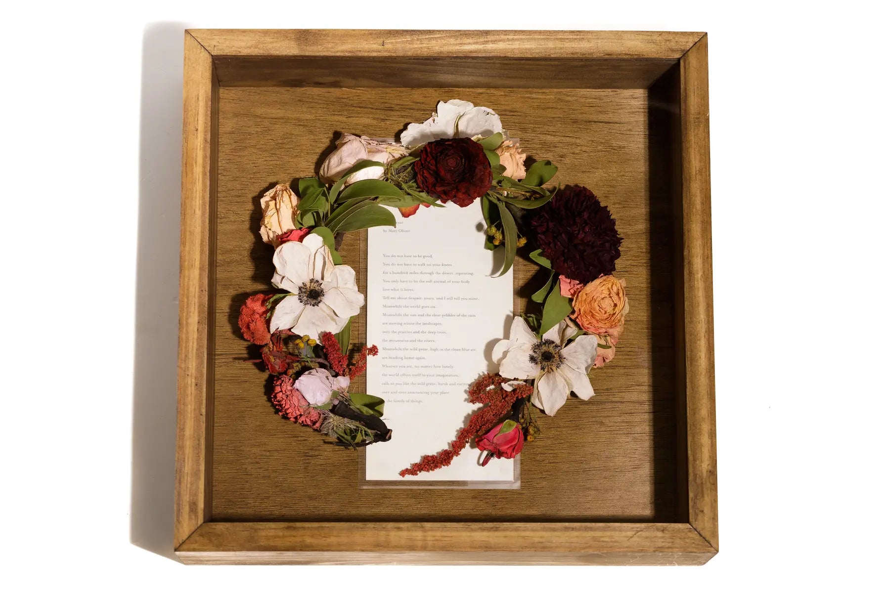 Wooden shadow box frame with floral wreath and vows card center framed