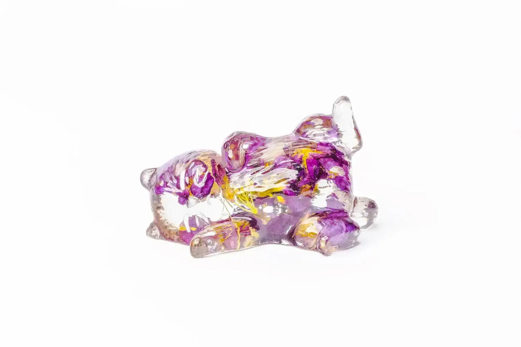 Playful cat on its side as a resin preservation for purple hued wedding flowers