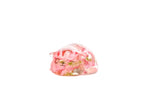 Small sleeping cat with one eye open as a pink flower resin preservation