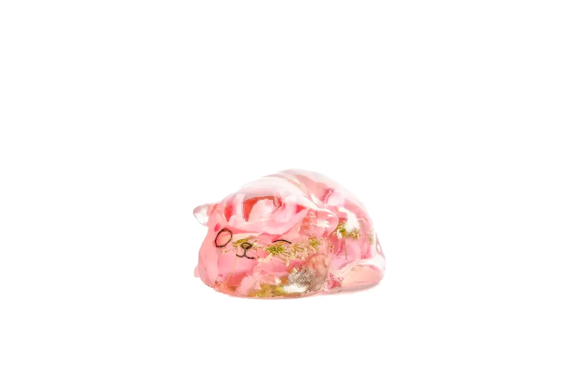 Small sleeping cat with one eye open as a pink flower resin preservation