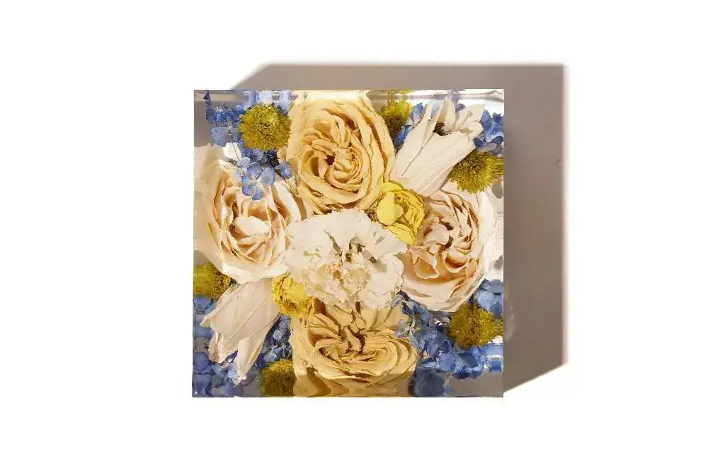 A 6 inch square bouquet block preserving peach and pink roses in a resin keepsake.