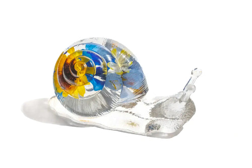 Handmade glass snail figurine with colorful shell of preserved wedding flowers
