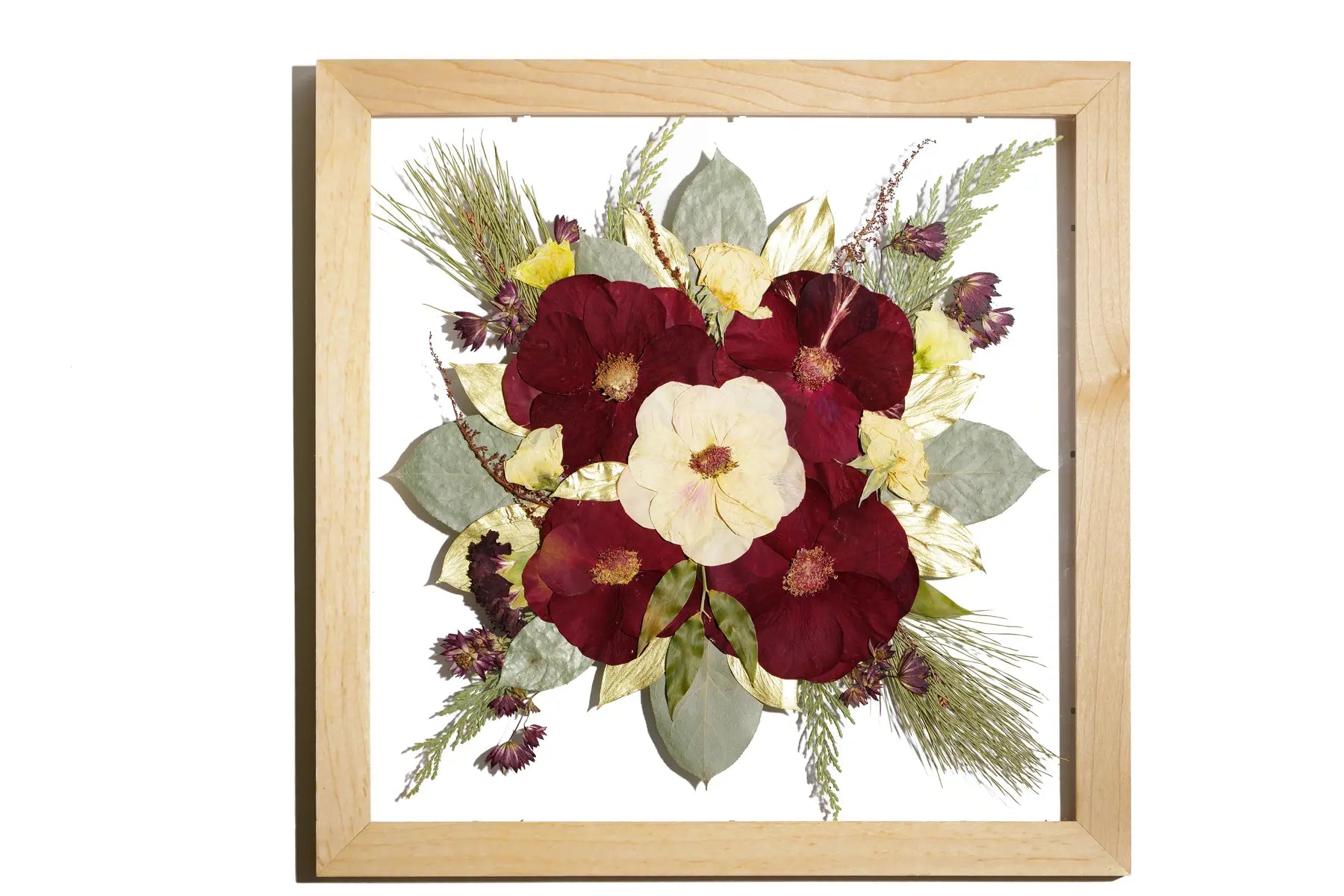 A square natural wooden frame with bright and autumnal wedding flowers in a floating design