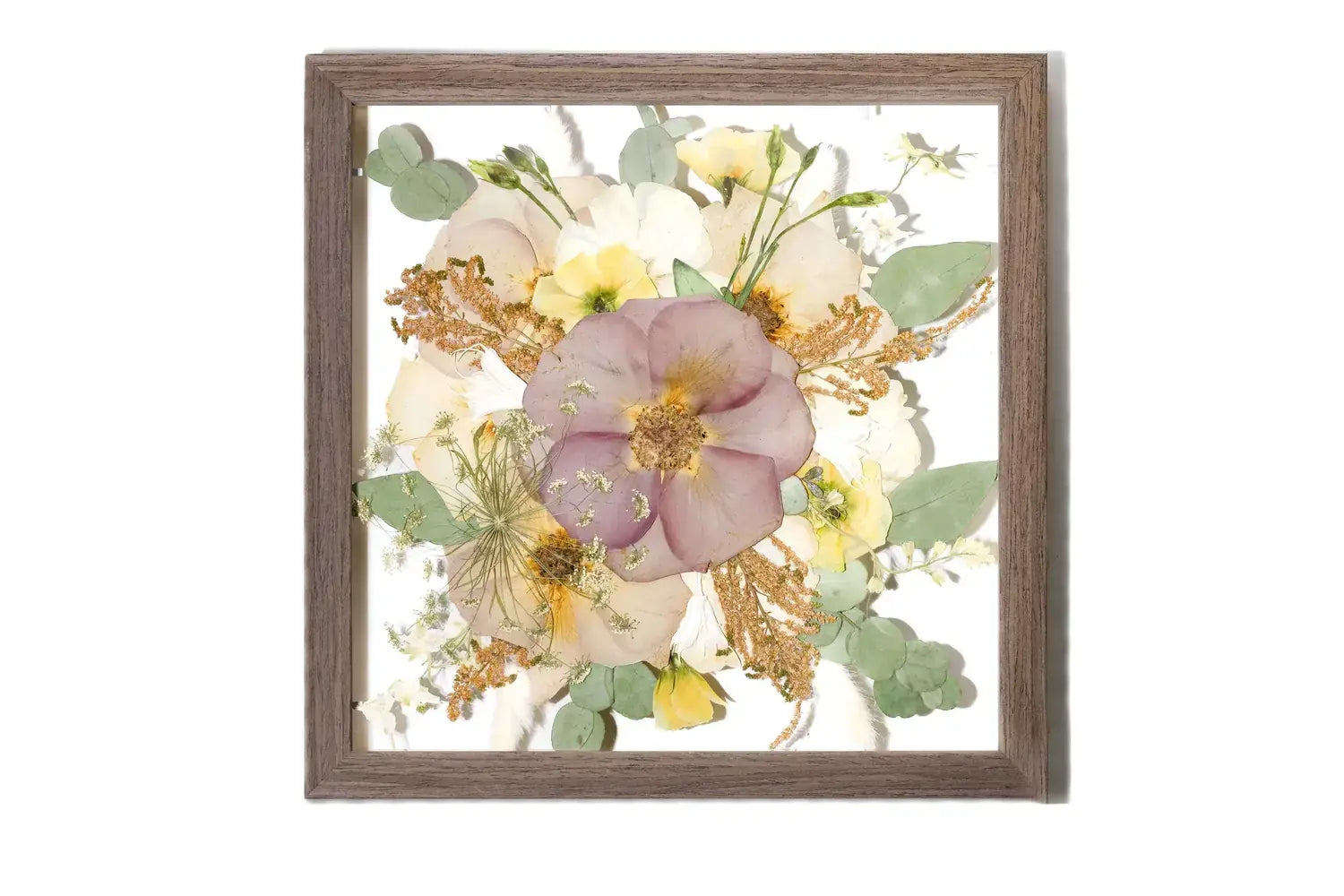 Framed wedding floral arrangement preserved and color corrected in a brown wooden frame