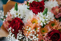 Close-up of bouquet of red roses and mixed variety of flowers